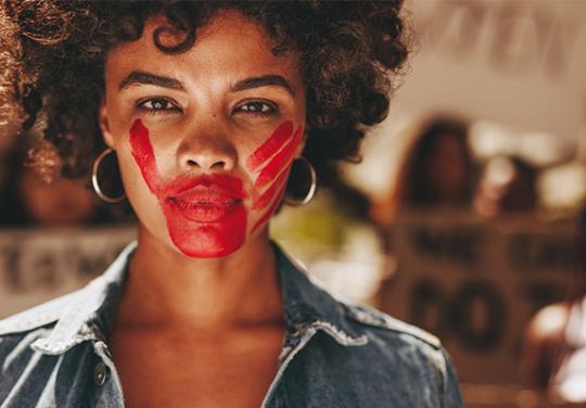 Main rouge sur visage de femme